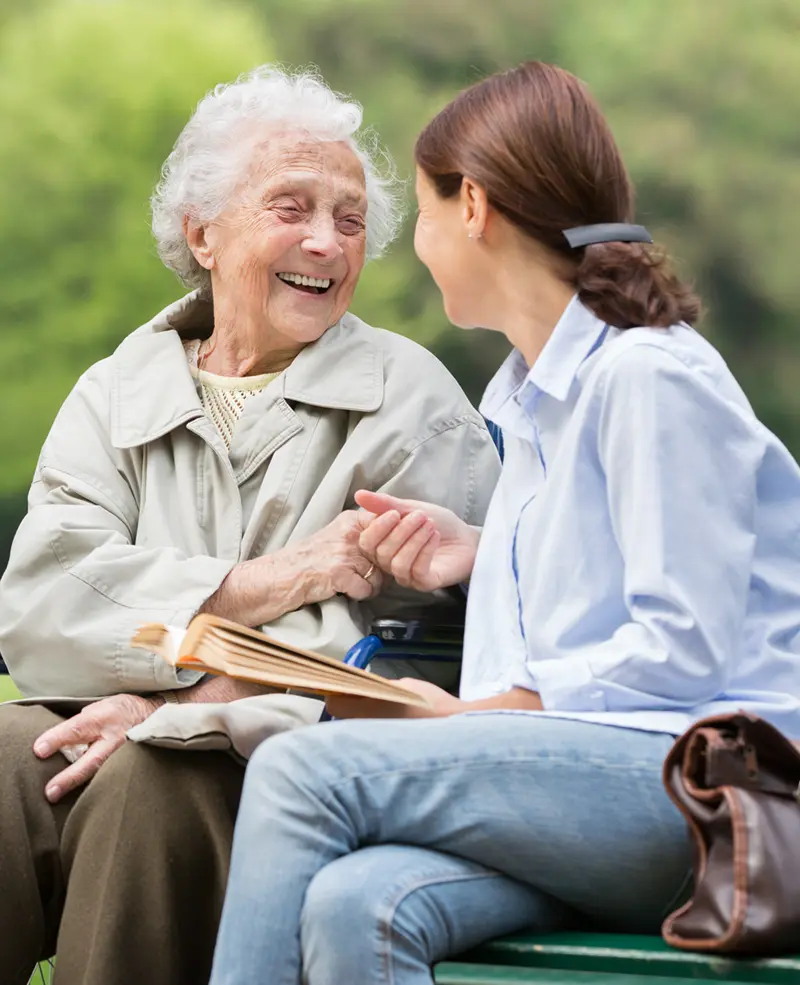 Care giver and resident outside having a friendly conversation